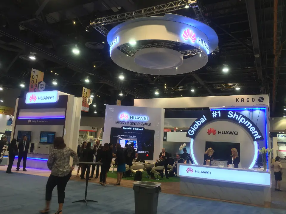 Show-day view of attendees in front of the arch, counter and wall screens