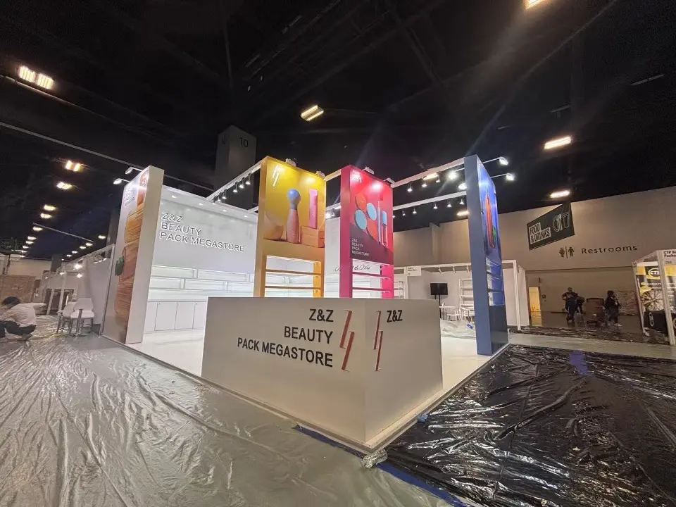 Wide view of the TAZ Beauty counter with red logo and colour block towers behind