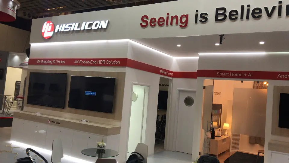 Booth face with lit HiSilicon lettering, red banding and wall screens
