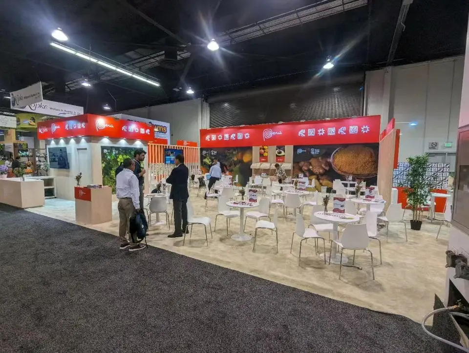 Open seating area with white tables and chairs inside the Peru pavilion
