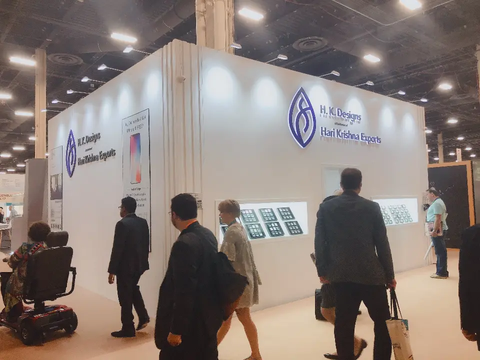 Aisle traffic passing the lit jewelry windows along the white cube walls