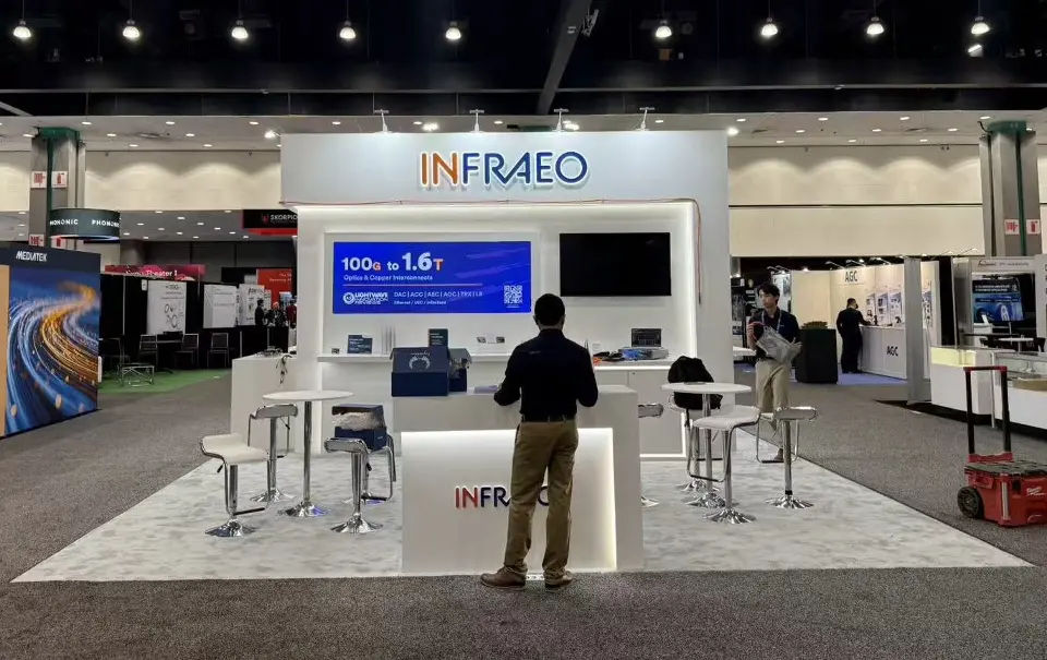 White Infraeo stand with a front counter, wall screens and high stools on a light floor