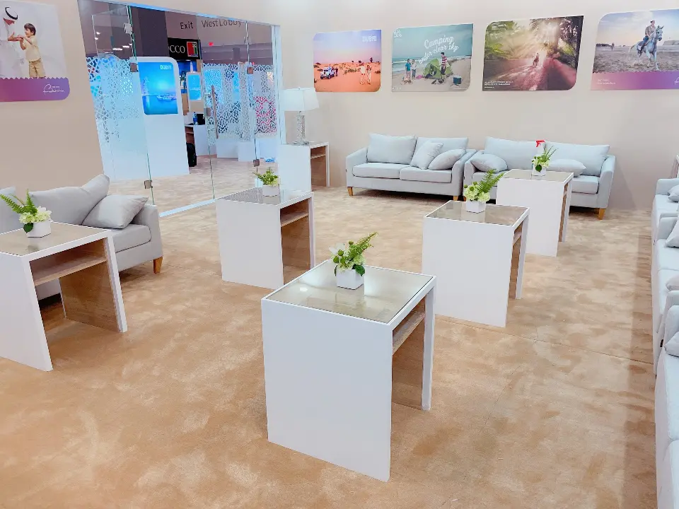 Lounge seating with white side tables and potted plants