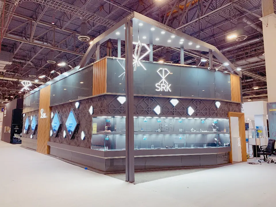 Side elevation with row of lit showcases below the SRK sign and spotlights