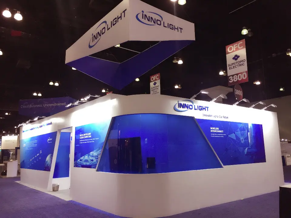 Booth corner with blue glass panels and the hanging sign above