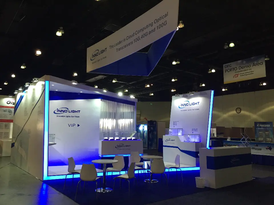 Front view of the InnoLight booth with display tables and blue base lighting