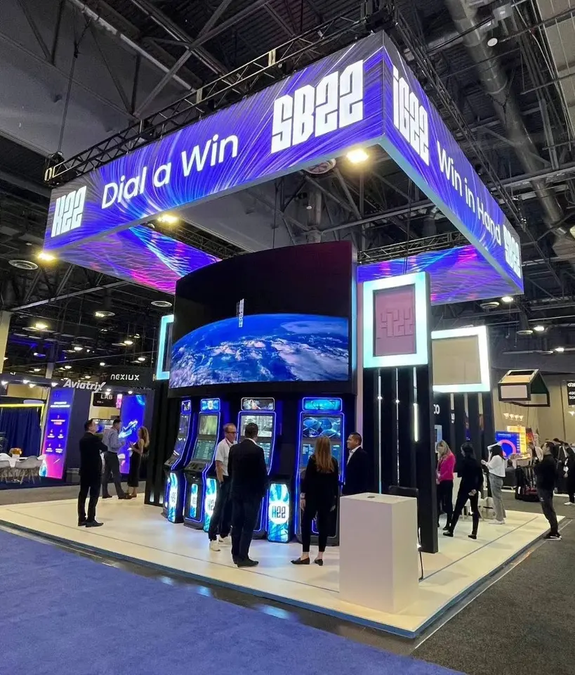Corner view of the SB22 booth with purple Dip a Win header above gaming cabinets