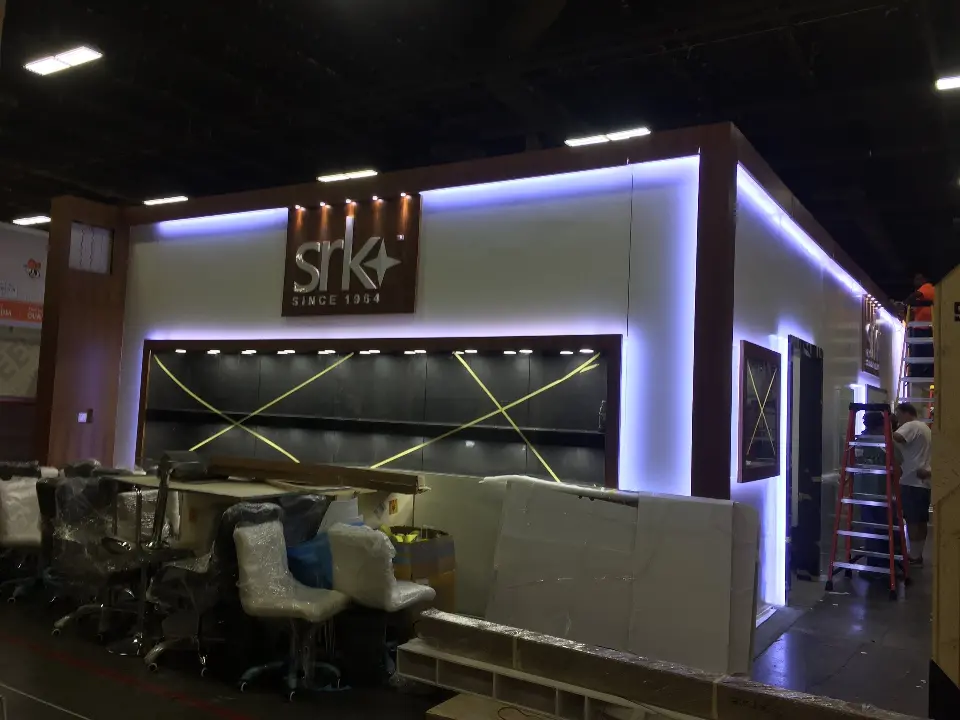 Slightly left angle of the lit facade with white chairs stacked by the showcase