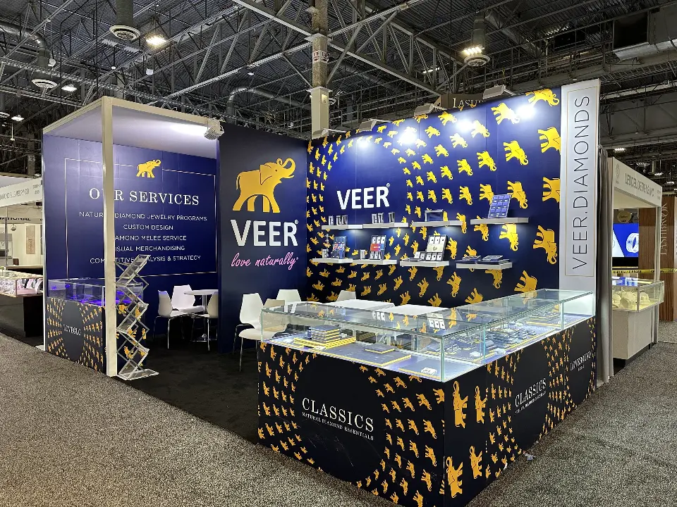 Full corner view of the Veer booth with elephant-pattern walls and showcase counters