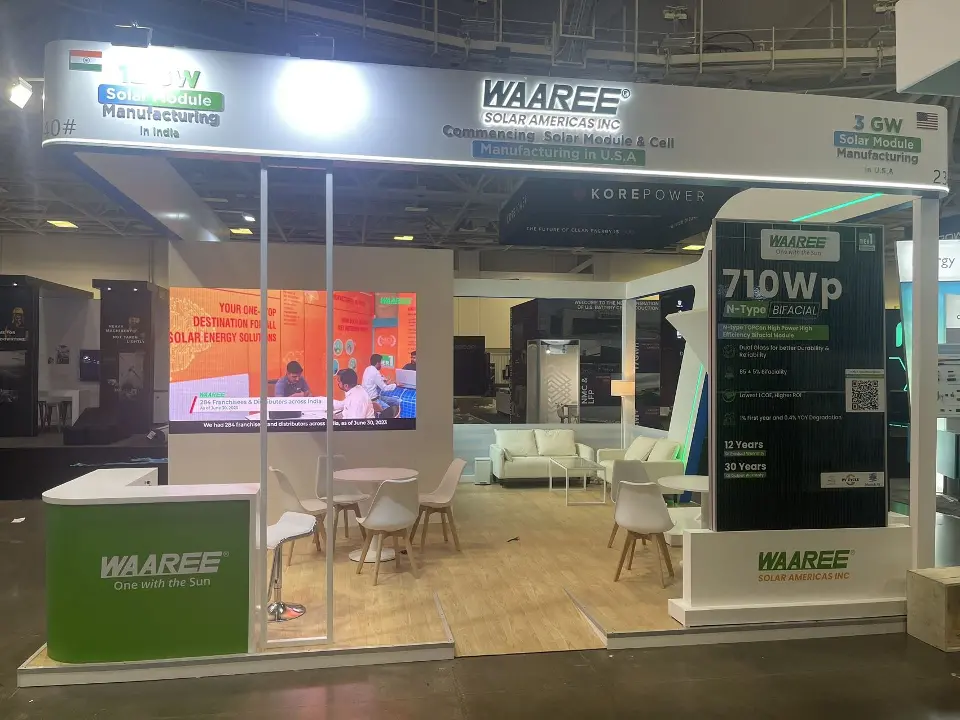 Open booth front with 710Wp display, seating area and green WAAREE counter