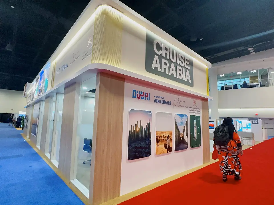Cruise Arabia corner with travel photography panels and a visitor on red carpet