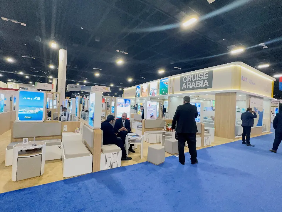 Visitors at meeting tables inside the pavilion with lit graphic columns