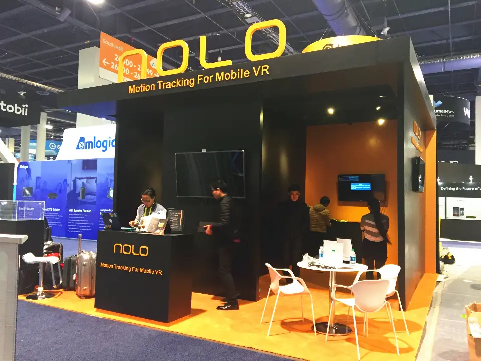 Black NOLO cube booth with orange-lit interior and gold lettering