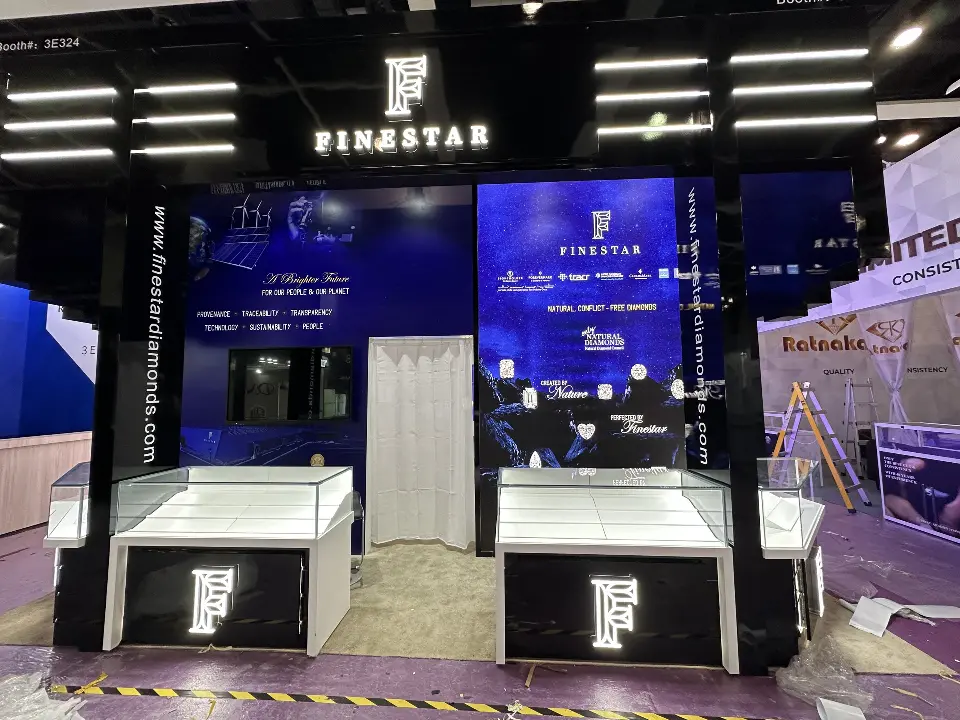 Front of the black booth with lit Finestar monogram, light bars and white showcases