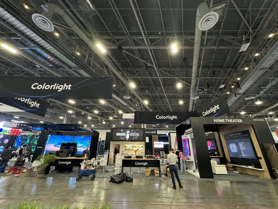 Wide hall view of black Colorlight walls under the hanging logo sign