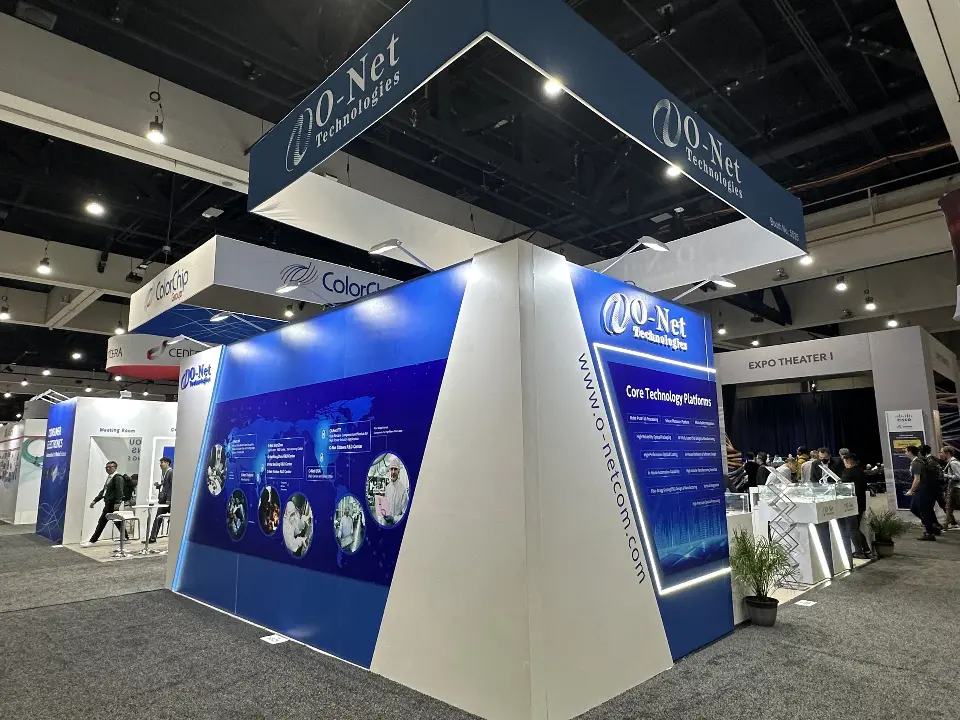 Corner view of the navy and white angled O-Net booth with square hanging sign