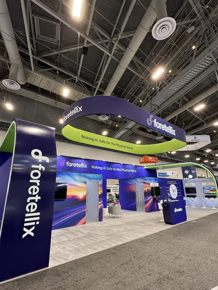 Tall navy Foretellix column at the booth corner with side walls behind