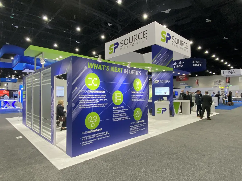 Source Photonics side wall with product graphics, frosted meeting rooms and visitors in the aisle