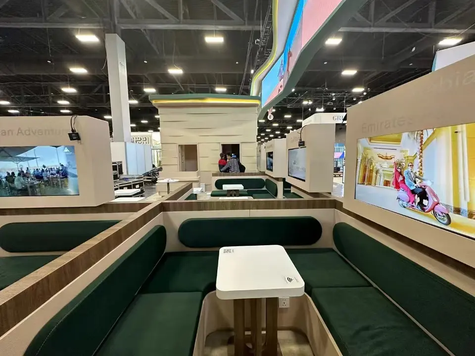 Close view of a green upholstered meeting booth with a white side table inside the Abu Dhabi pavilion