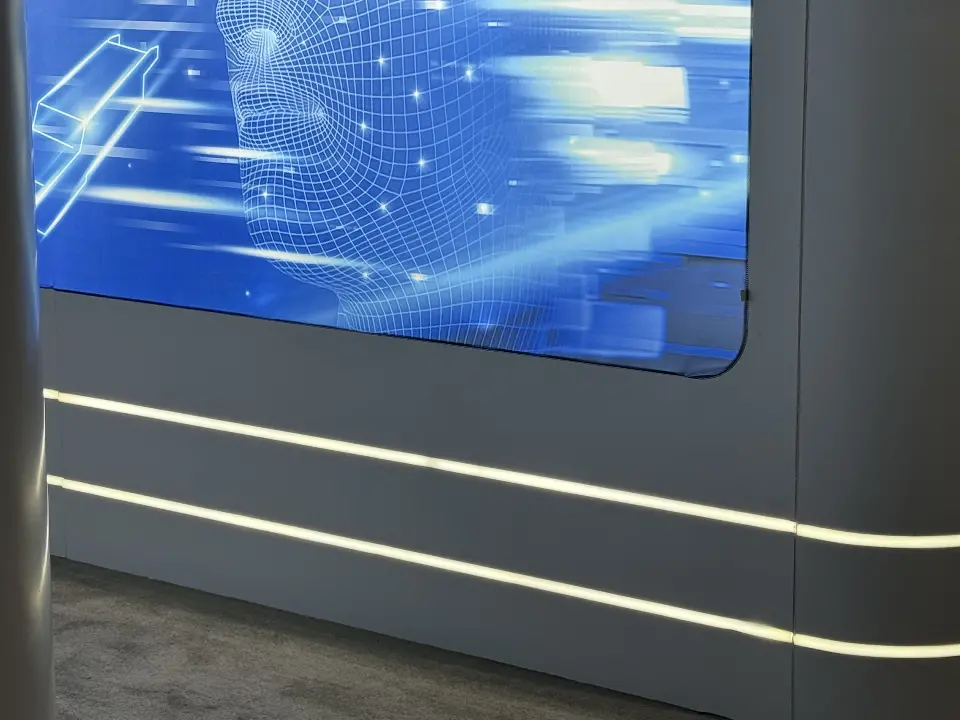 Parallel light lines on the grey wall beside a blue backlit panel