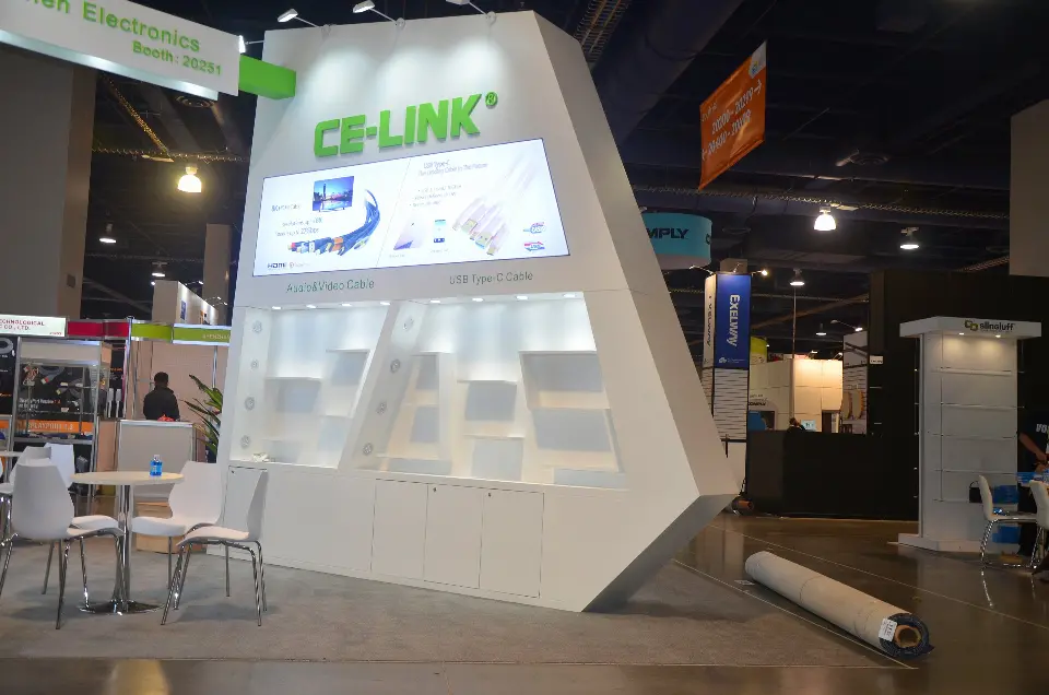 Side of the angled wall with a backlit display panel and tables