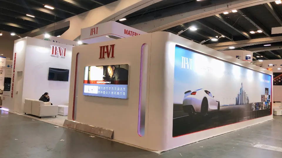 Corner view of the white booth with wall screen and car skyline graphic