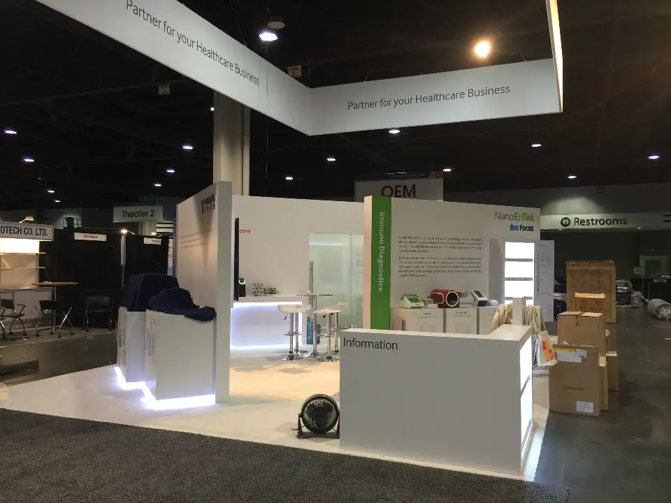 Open white booth area with low counters and wall graphics ready before opening