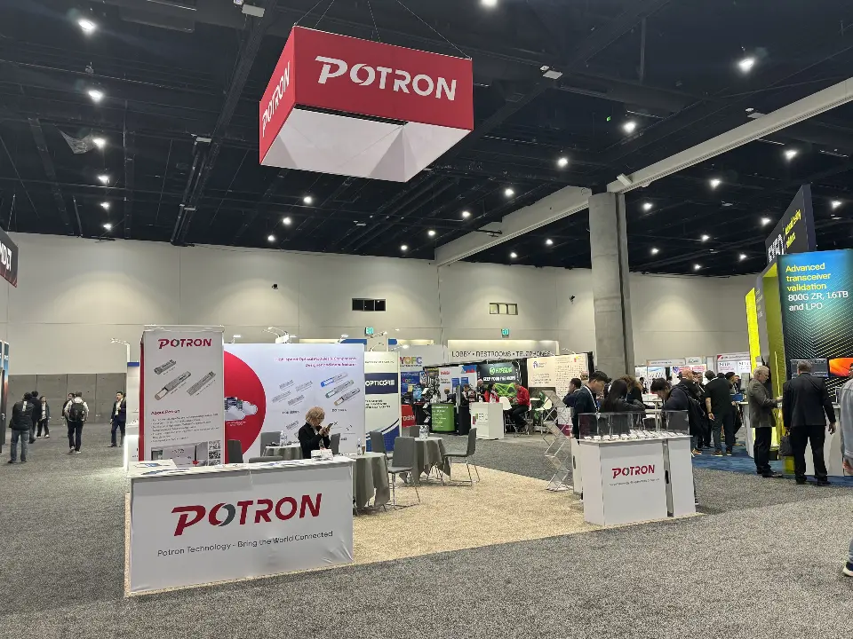 Wide view under the red POTRON hanging sign with printed counter and product walls