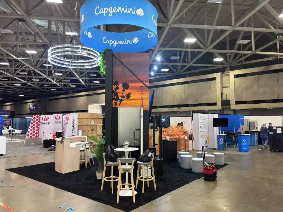 Capgemini island stand with round hanging sign, central tower and bar tables