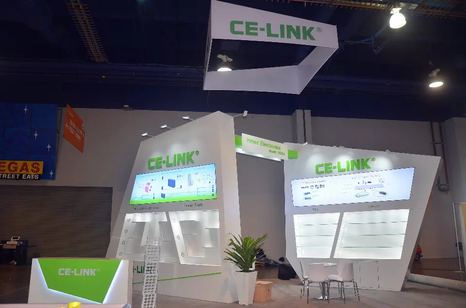 Angled white walls with backlit graphics, green counter and a potted plant