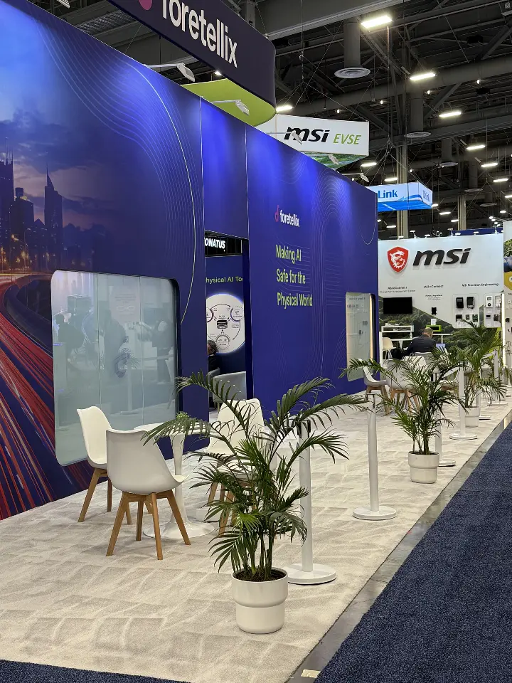Back wall of the booth with palm, white chairs and navy panels