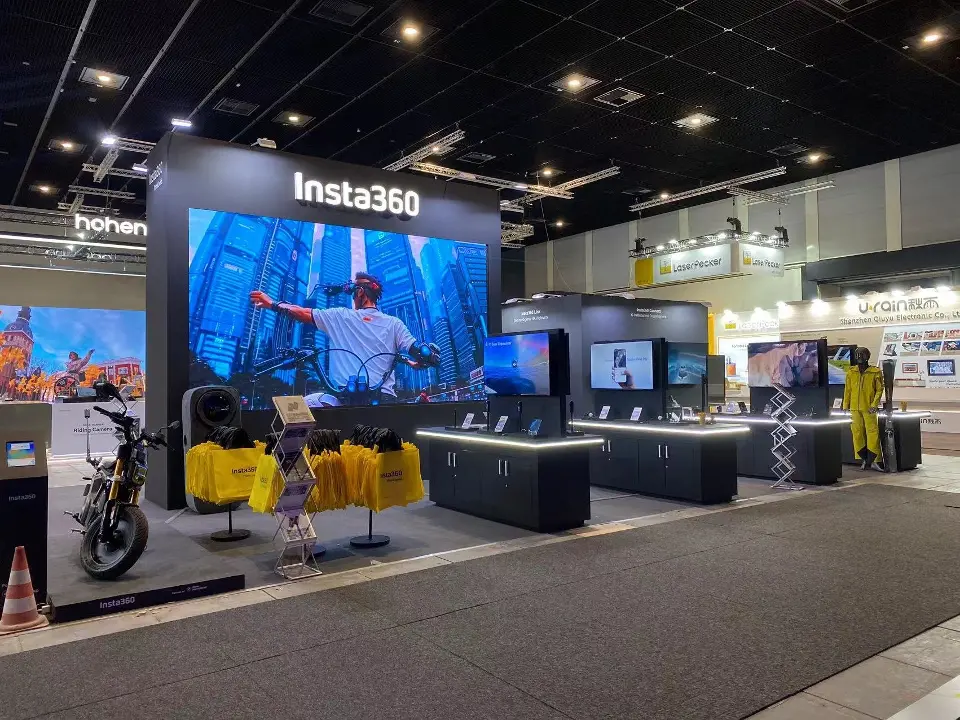 Front view of the large video screen under the lit Insta360 logo with a motorcycle display