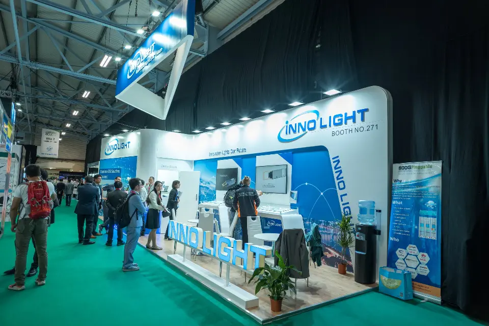 Side view along the InnoLight booth with visitors gathered at the counters