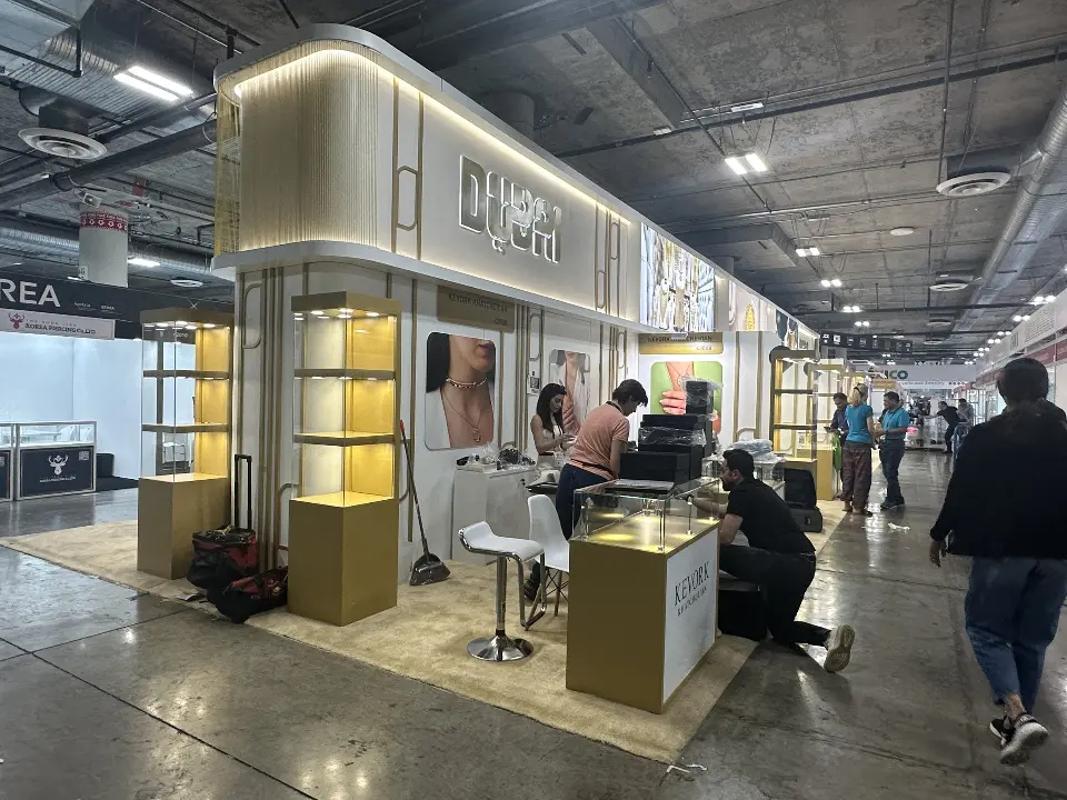 Visitors seated at a white table inside an open exhibitor bay
