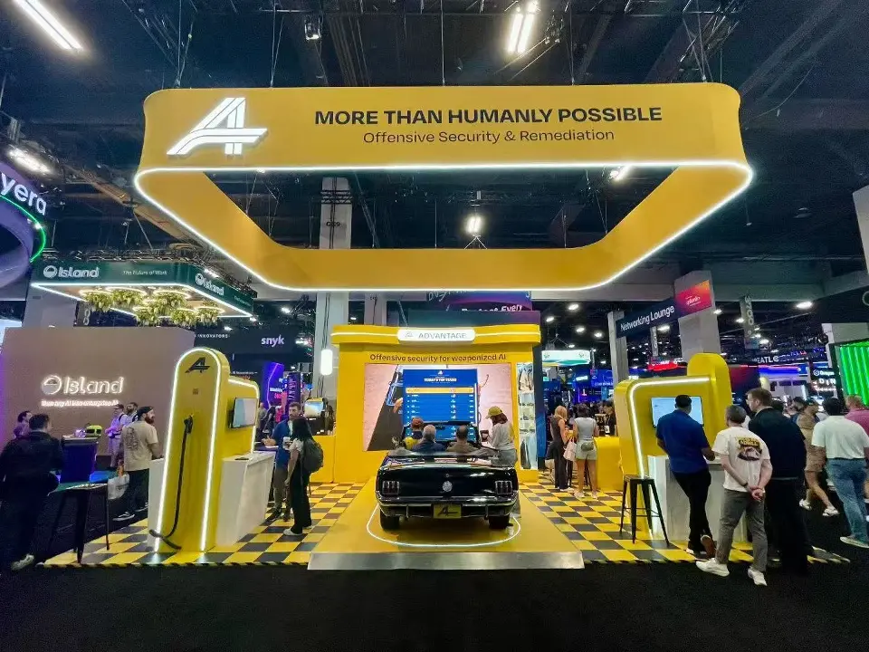 Full Advantage booth under the More than humanly possible hanging frame, seen from the aisle