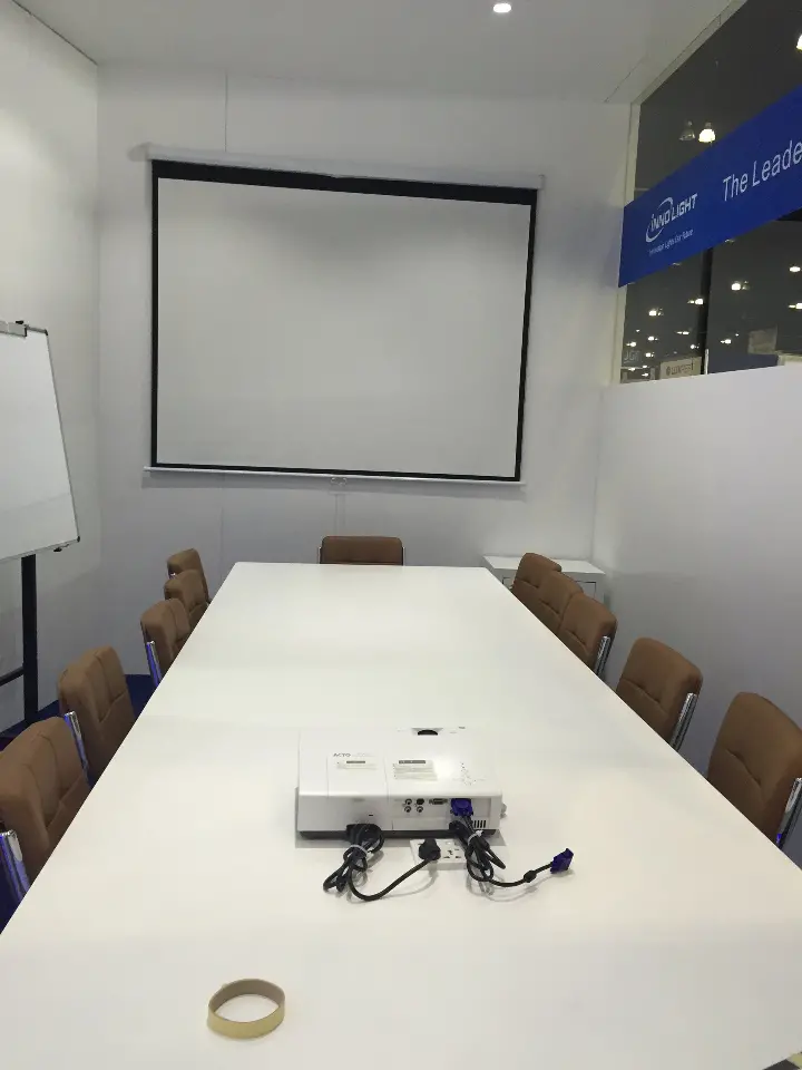Portrait view of the meeting table and projector in the white room