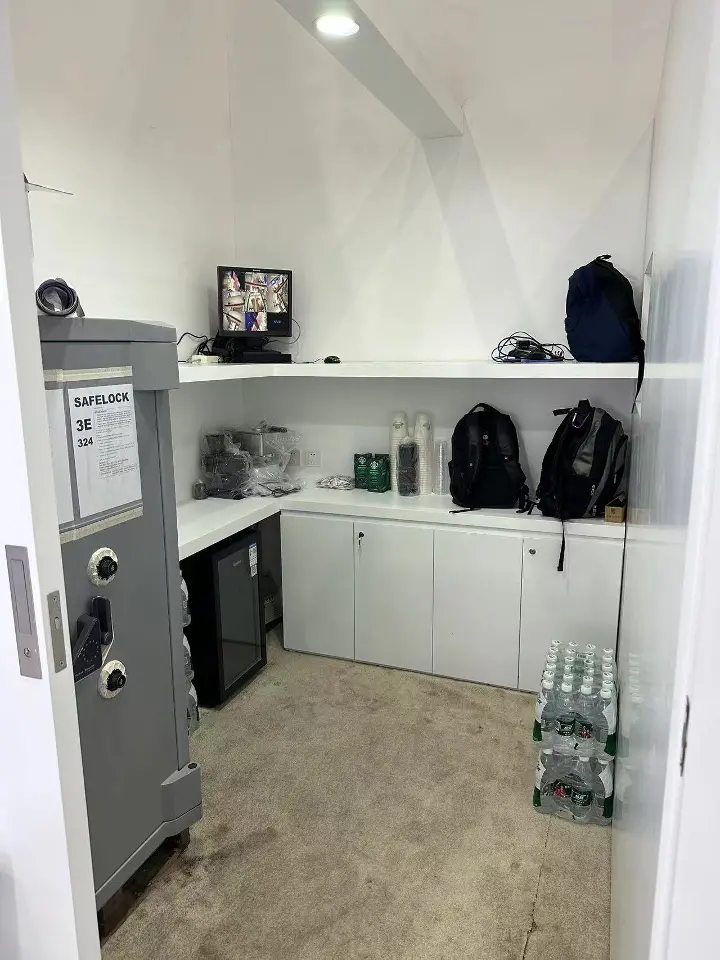 Portrait of a back storage room with white shelves and a grey safe