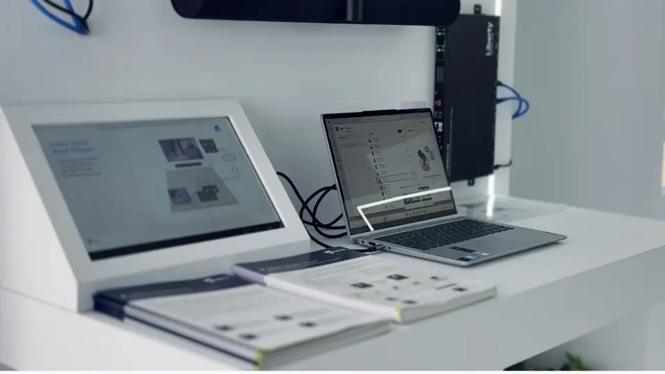 Laptops and tablets running demos on a white display shelf