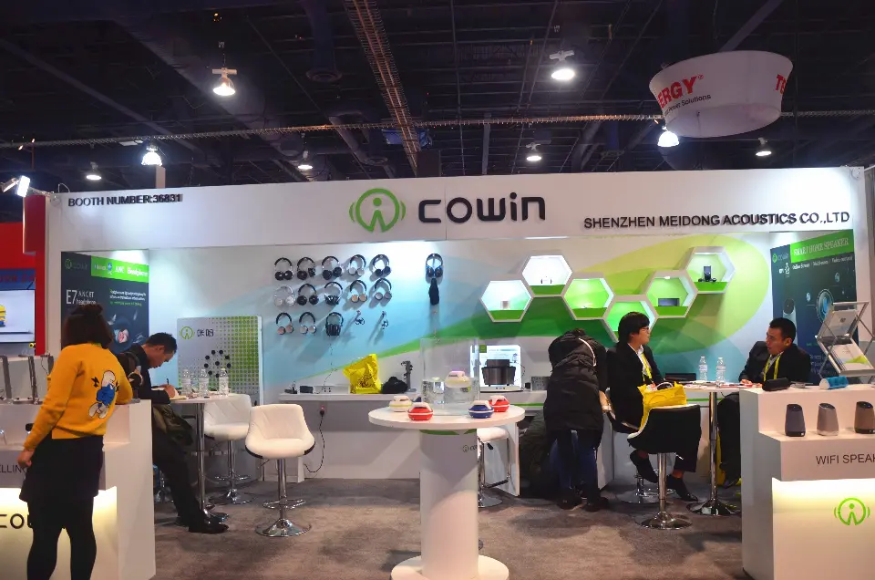 Cowin booth at CES 2017 with white fascia, green swoosh back wall and hexagon niches