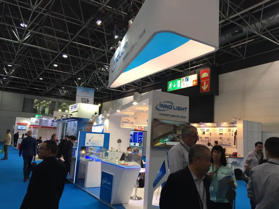 Side angle of the curved InnoLight header above product displays on blue carpet