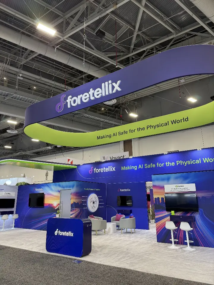Angled front view of the navy booth, lime-green ring and branded welcome counter