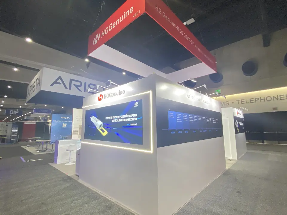 Angled view across the booth showing white backlit walls and the dark blue outer wall