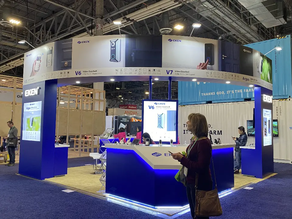 Visitor walking past the blue-lit counter with screens on navy walls behind