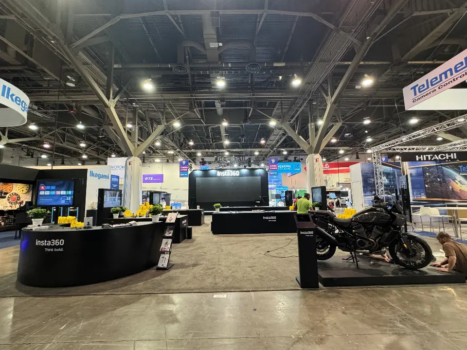 Wide view of the curved black Insta360 counter, demo screens and motorbike plinth