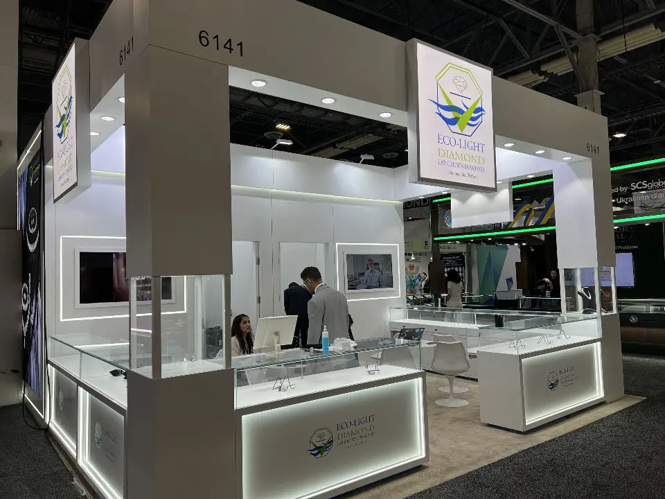 Front of booth 6141 with framed video screens, white portal headers and showcases with lit edges