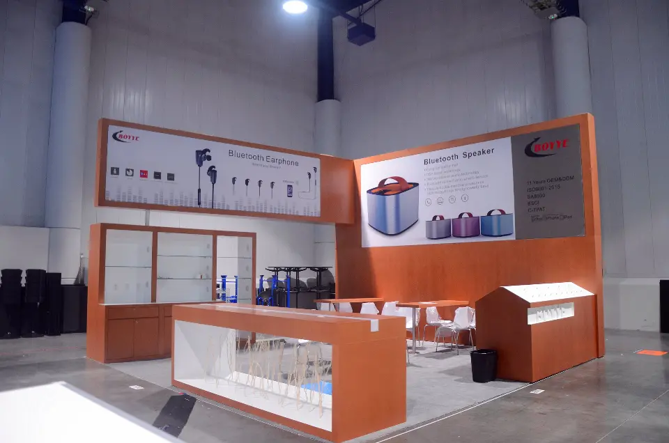 Finished L-shaped booth with wood-look walls, display shelving and white counters