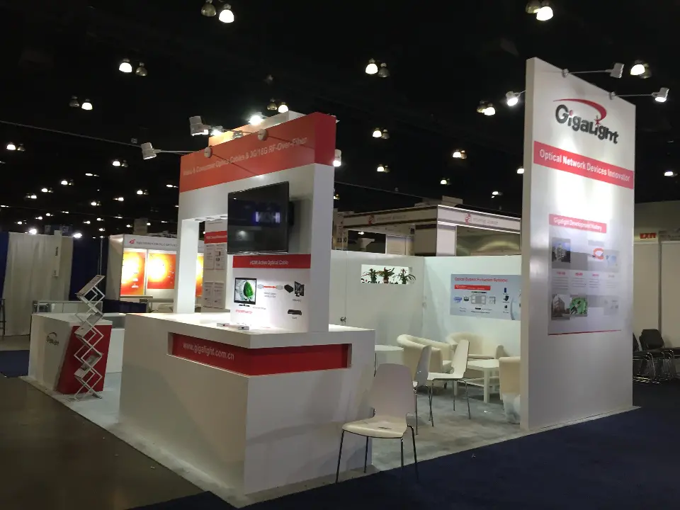 Gigalight booth with white chairs, counters, wall screen and red-band tower