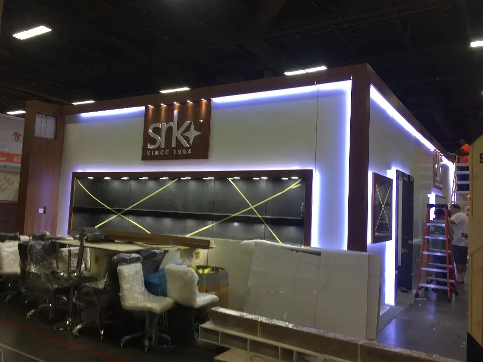 Front view of the white booth with walnut-look trim, lit edges and long showcase