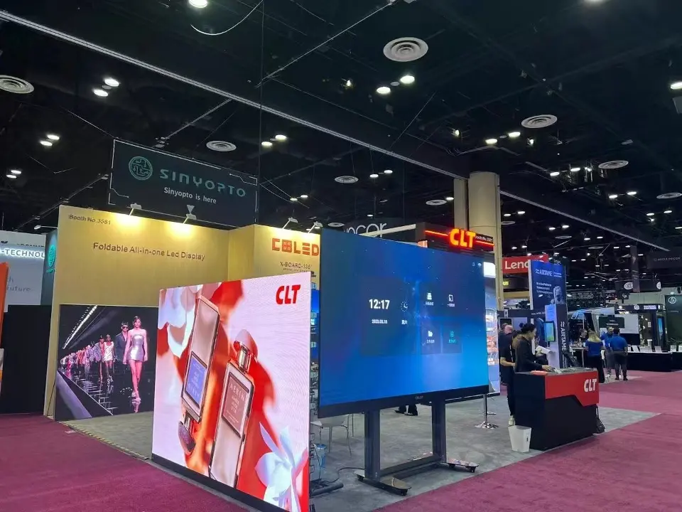 Opposite side of the CLT booth at InfoComm with freestanding display screens and a red CLT counter