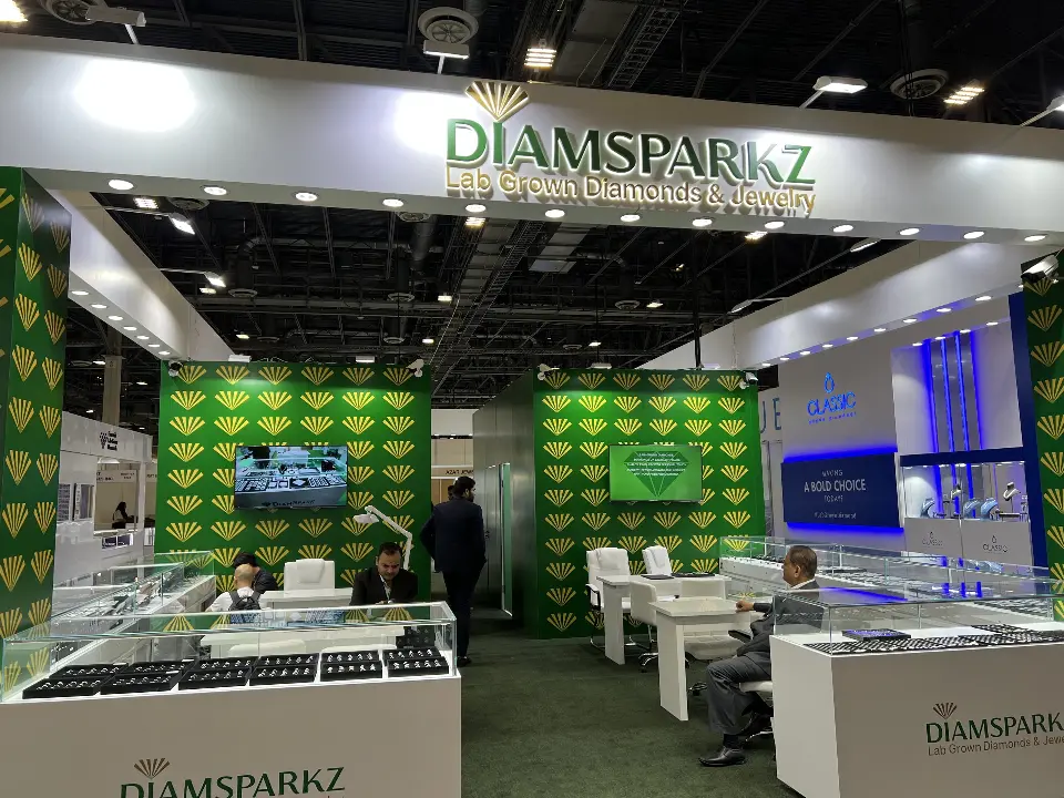 Front view under the lit Diamsparkz header showing ring trays, white meeting chairs and green carpet